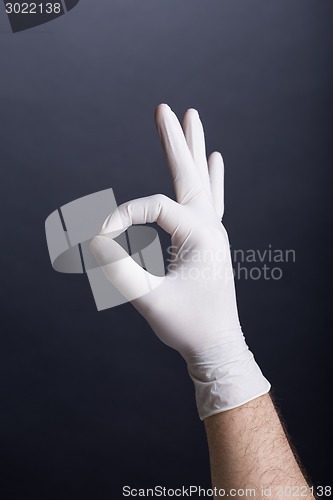 Image of Male hand in latex glove (OK sign)