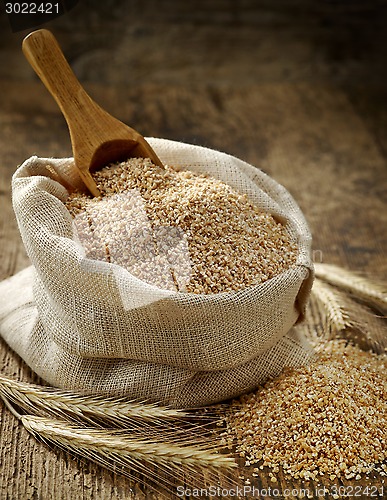 Image of wheat grits sack on old wooden table