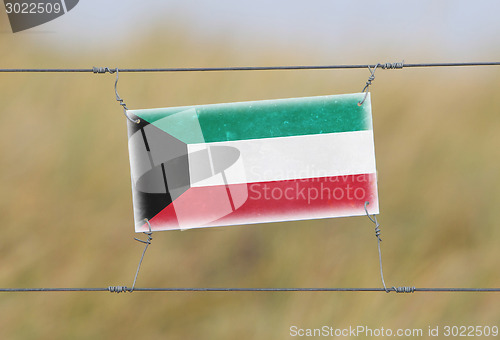 Image of Border fence - Old plastic sign with a flag