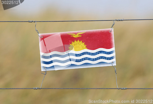 Image of Border fence - Old plastic sign with a flag