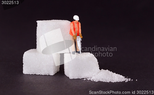 Image of Miniature worker working on a sugar cube