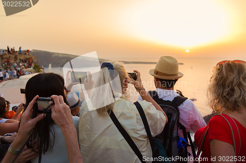 Image of Trvellers watching sunset in Oia, Santorini, Greece.