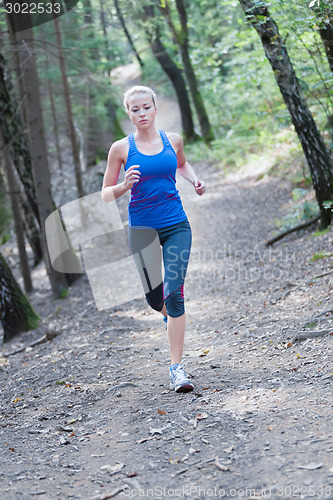 Image of Pretty young girl runner in the forest. 