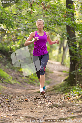 Image of Pretty young girl runner in the forest. 