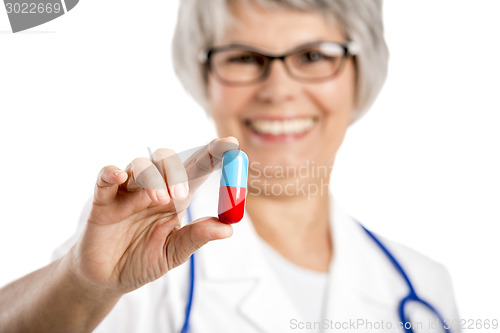 Image of Female doctor holding  a pill