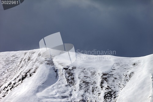 Image of Off-piste slope and storm gray clouds