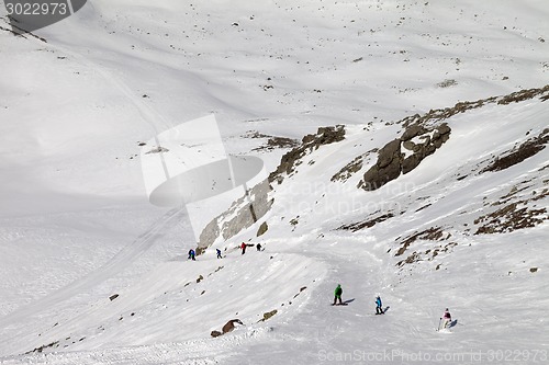 Image of Snowboarders and skiers on ski slope at sun day