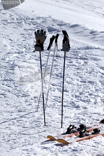 Image of Skiing equipment on ski slope at sun day