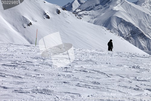 Image of Ski trail and snowboarder in sun nice day