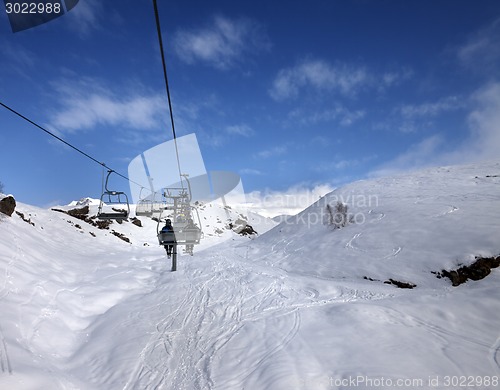 Image of Chair-lift and off-piste slope in sun day