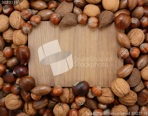 Image of Mixed nuts frame a wooden background