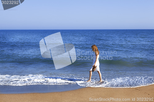 Image of Holidaymaker with feet in wate