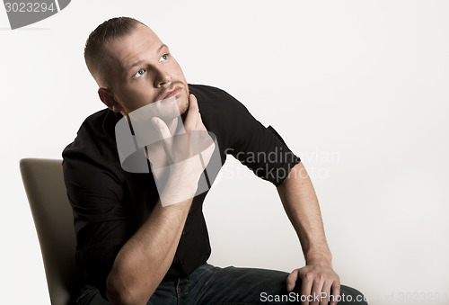 Image of young man sitting looking up