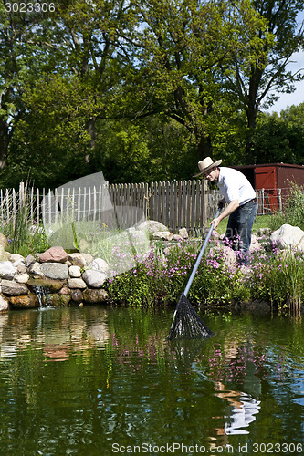 Image of man fishes in garden pond