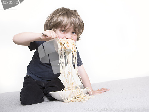 Image of Child eating spaghetti joyfully