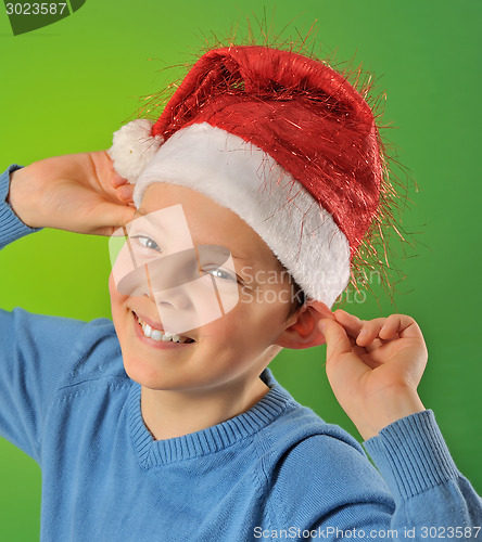 Image of boy with Santa Claus Hat on green background