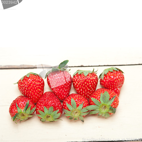 Image of fresh organic strawberry over white wood