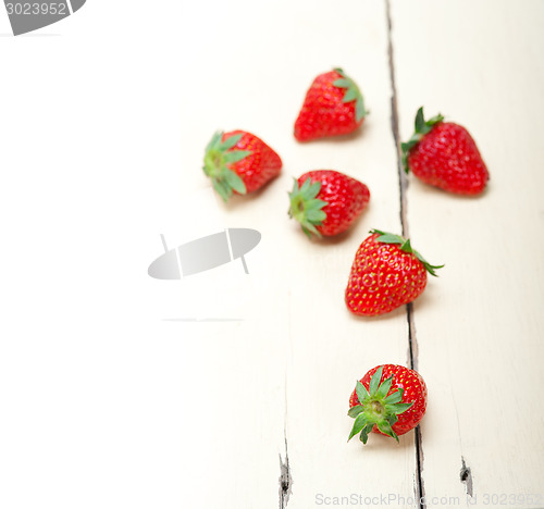 Image of fresh organic strawberry over white wood