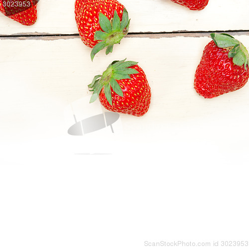 Image of fresh organic strawberry over white wood