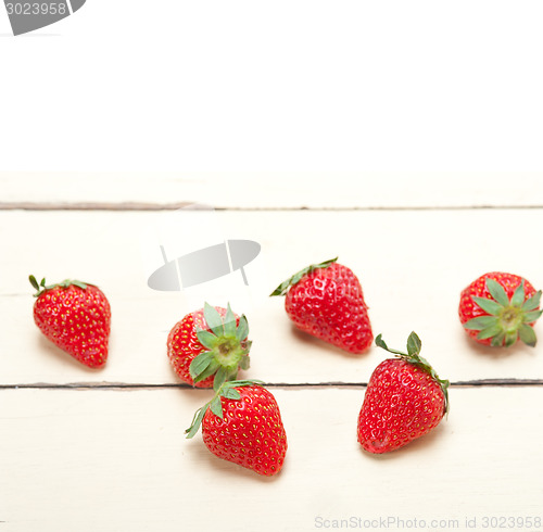 Image of fresh organic strawberry over white wood