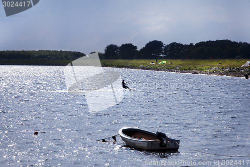 Image of kitesurfer with motorboat