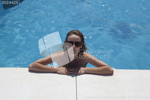 Image of woman with sunglasses bathes in pool