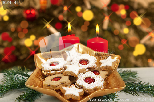 Image of biscuits and candles under christmas tree