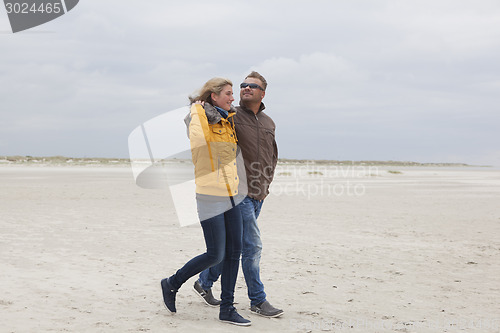 Image of Couple goes on a sandy beach in autumn