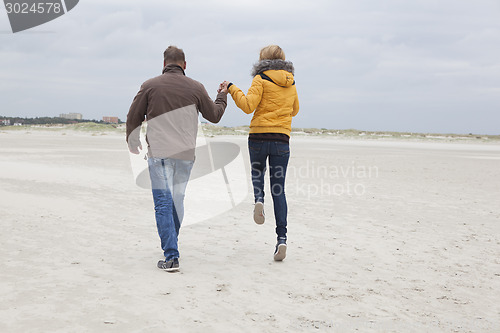 Image of Couple on the sandy beach in autumn
