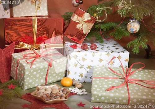 Image of christmas gifts beside christmas tree