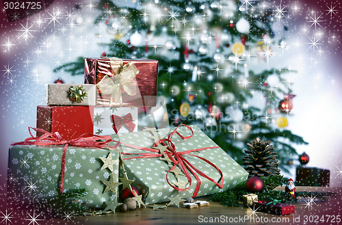 Image of Christmas gifts in front of Christmas tree and stars
