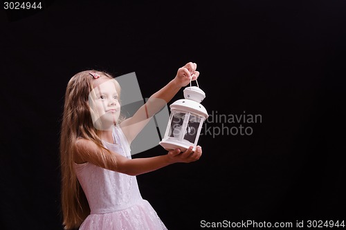 Image of Five-year girl shines candlestick into the distance