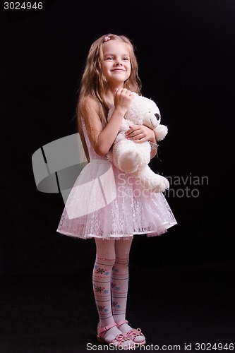 Image of Happy girl standing with teddy bear