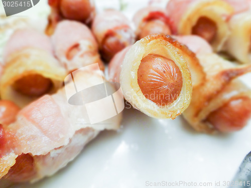 Image of hot dog weiners in a bacon blanket