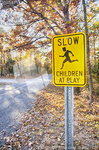 Image of Yellow Slow Children at Play Road Sign and road