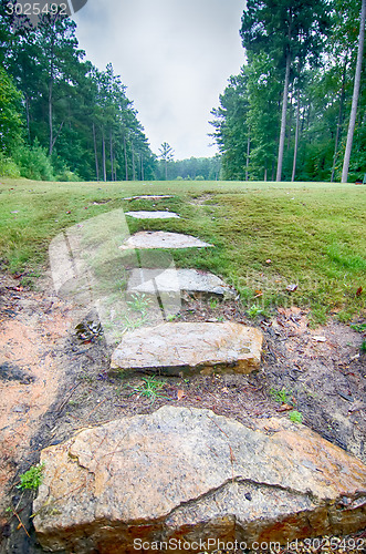 Image of stone step stair leads to an open golf course