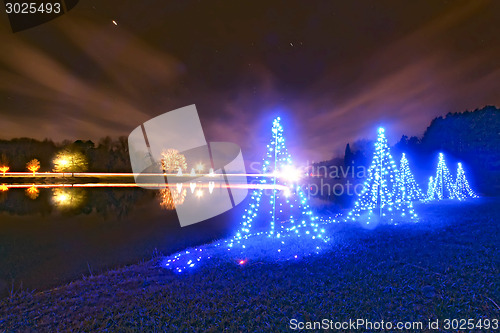 Image of outdoor christmas decorated trees near a lake