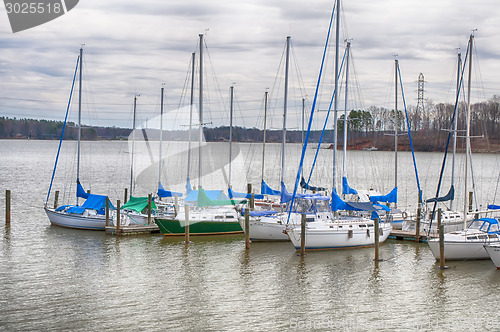 Image of parked yachts in harbour with cloudy skies