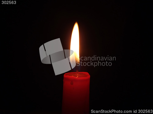 Image of The red candle burning in full darkness