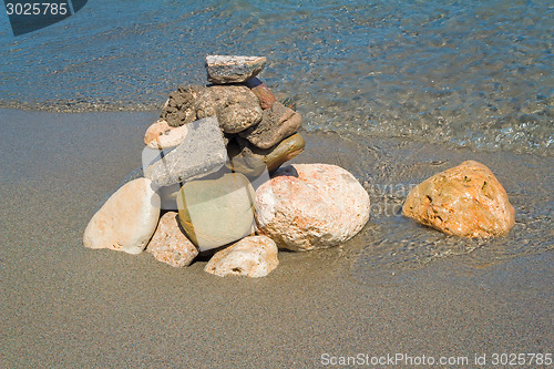 Image of Small sea stones on the seashore, covered with a sea wave.