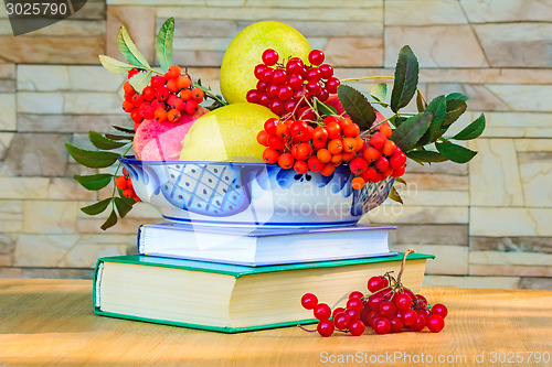 Image of Still life: books and fruit and berries in a beautiful vase.