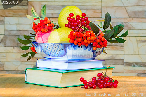 Image of Still life: books and fruit and berries in a beautiful vase.
