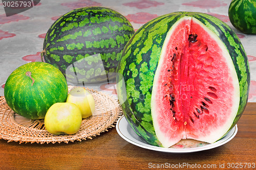 Image of Ripe sliced watermelon and apples.