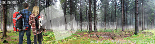 Image of Couple hiking through misty forest