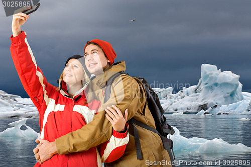 Image of Couple taking a selfie with icebergs in the background