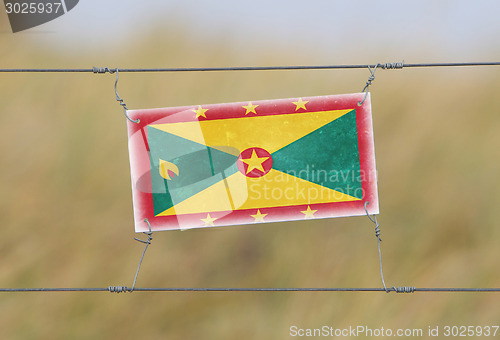 Image of Border fence - Old plastic sign with a flag