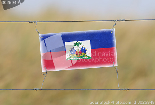 Image of Border fence - Old plastic sign with a flag