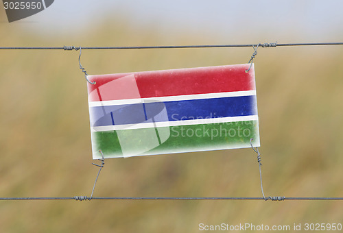 Image of Border fence - Old plastic sign with a flag