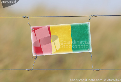 Image of Border fence - Old plastic sign with a flag