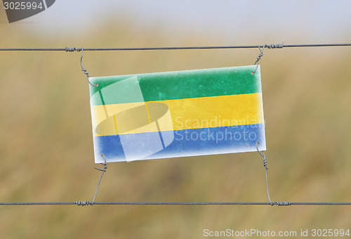 Image of Border fence - Old plastic sign with a flag